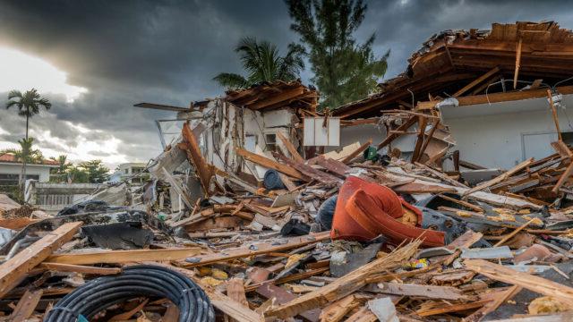 飓风马修造成的一堆建筑残骸，背景是夕阳西下