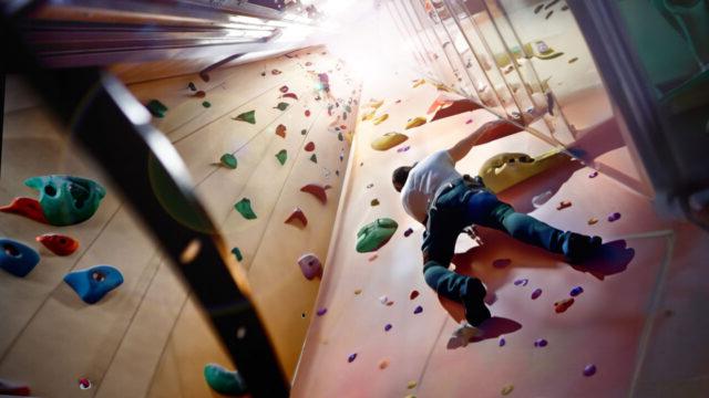 一名攀岩者正在攀爬由空电梯井改造而成的攀岩墙